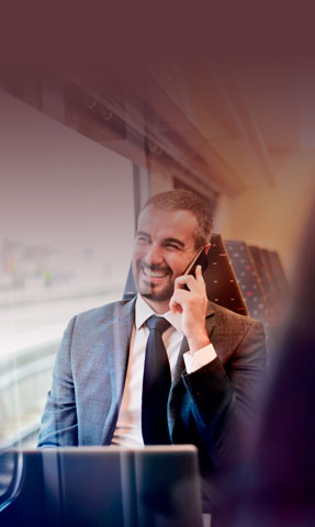 Hombre de negocios hablando por teléfono en un tren.