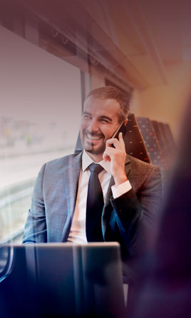 Hombre de negocios hablando por teléfono en un tren.