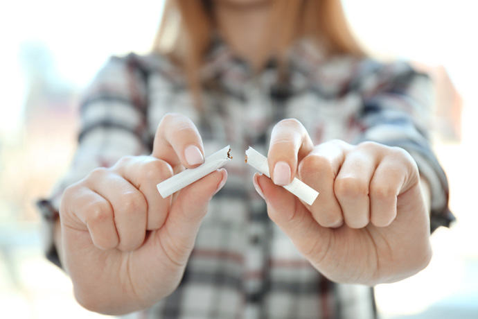 Mujer rompiendo un cigarro