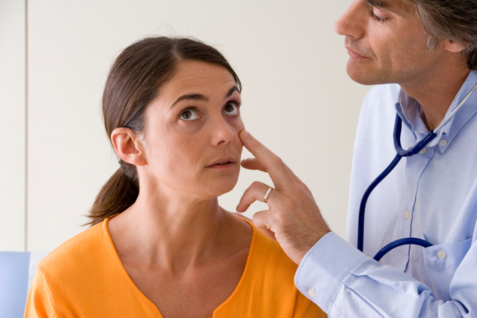 médico explorando el interior de los ojos de una mujer