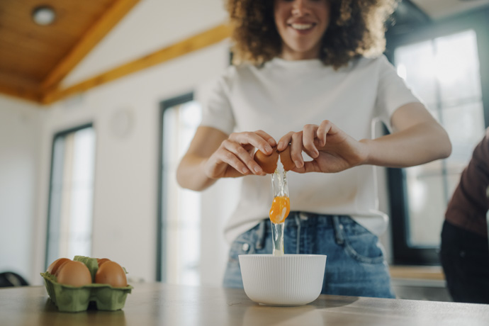 Mujer preparando receta con huevos