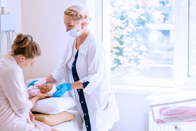 Doctora instruyendo a mamá como amamantar