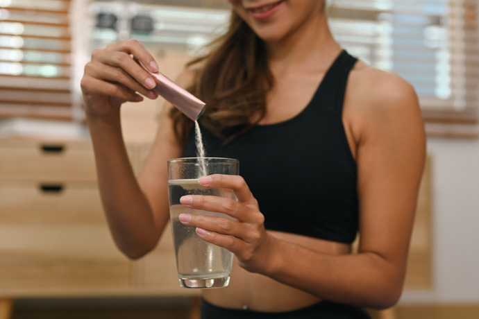 Mujer deportista usa suplemento de colágeno
