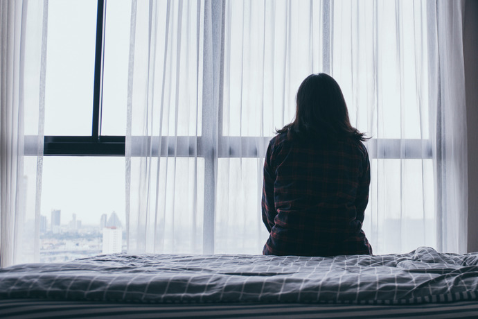 Mujer sentada en la cama se siente sola