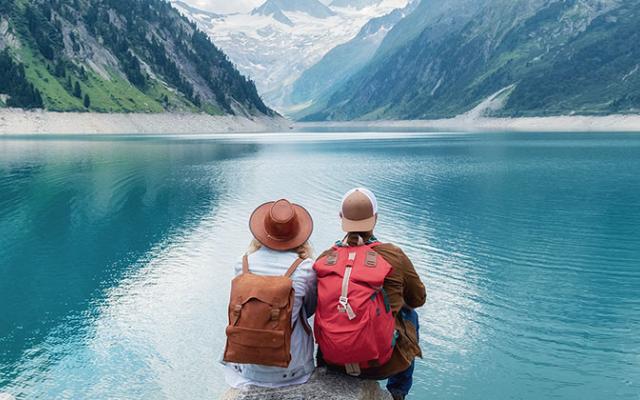 Dos personas sentadas frente a un lago.