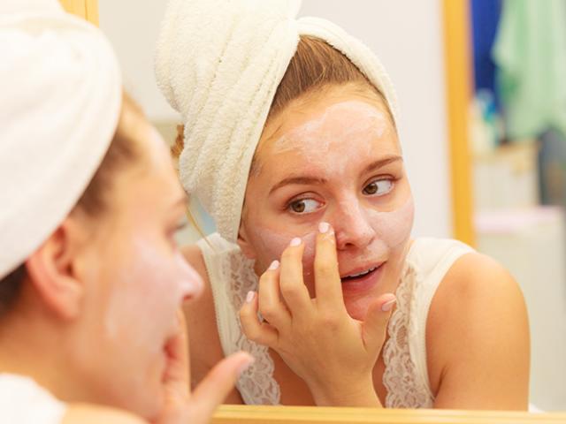 Mujer aplicando crema en el rostro