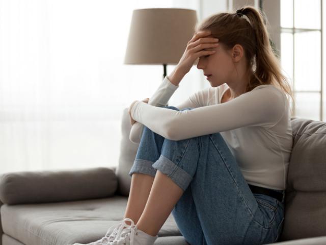mujer sentada en el sofá con pensamientos intrusivos