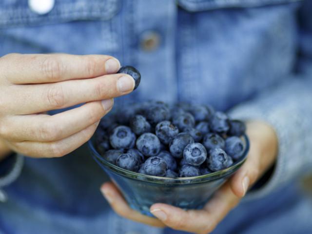 Persona comiendo arándanos