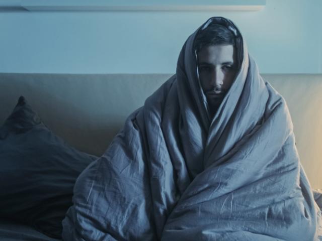 Persona con fiebre y escalofríos durante la noche