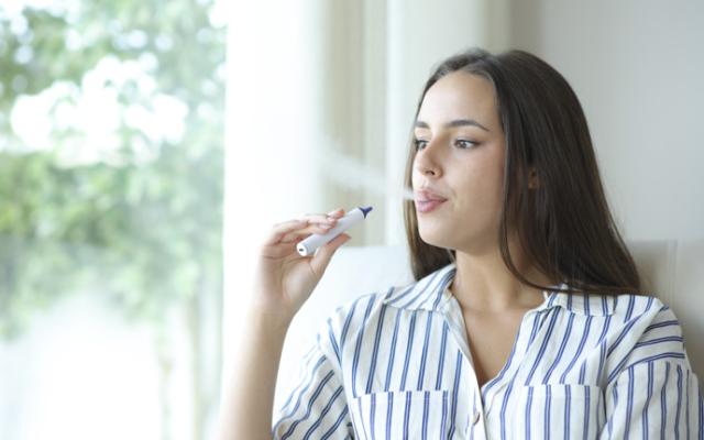Mujer joven vapeando 